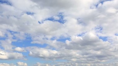 Cumulus bulutları mavi gökyüzünde süzülüyor. Timelapse görünümü.