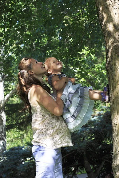 Vackra gravid kvinna med en ung dotter som spelar i en stad — Stockfoto