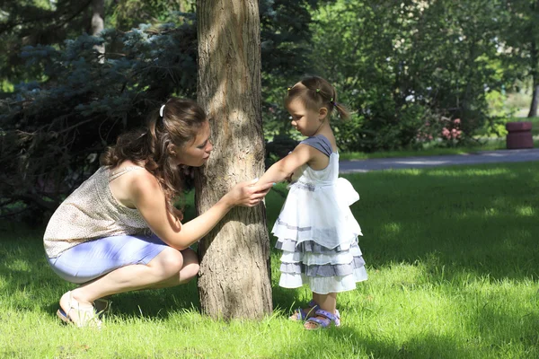 Den lille jenta viser sin mor insektbitt (i en bypark) ). – stockfoto