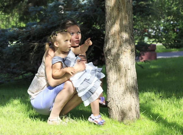 快乐妈妈和一个年幼的女儿在一个城市公园玩. — 图库照片