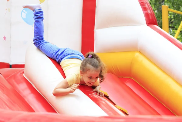 Fröhliches kleines Mädchen spielt auf einem Trampolin. — Stockfoto