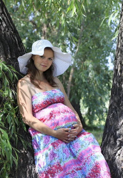 Mooie zwangere vrouw in een stadspark. — Stockfoto
