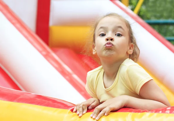 Joyeuse petite fille fait un visage sur un trampoline. — Photo