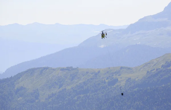 Helikopter die goederen vervoeren in de bergen (bouw). Krasn — Stockfoto