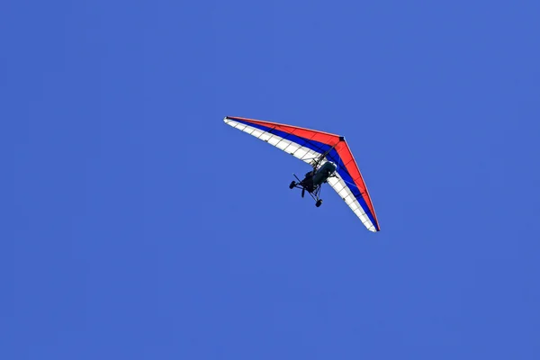 三轮车 (悬挂式滑翔机与电机） 映衬在蓝天下. — 图库照片