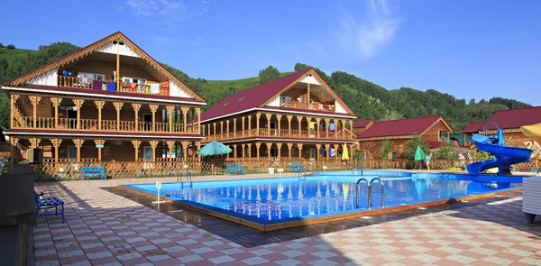 Belles maisons en bois avec piscine dans les montagnes . — Photo