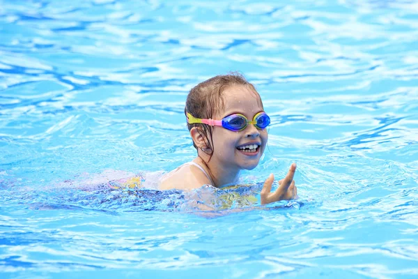 Niño alegre en gafas de baño en la piscina al aire libre . — Foto de Stock