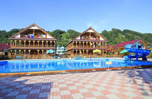 Beautiful wooden cottages with swimming pool in the mountains. — Stock Photo, Image