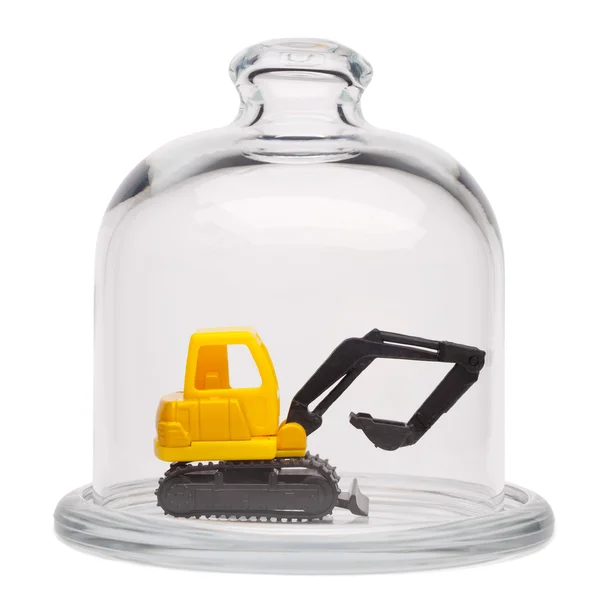Toy yellow excavator in a glass dome — Stock Photo, Image