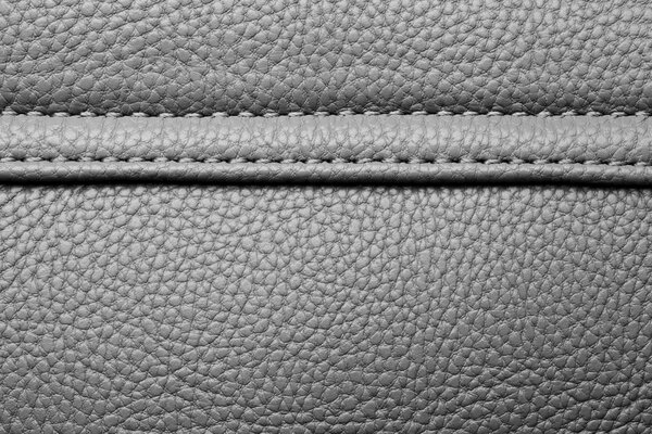 Texture of black leather with black stitching