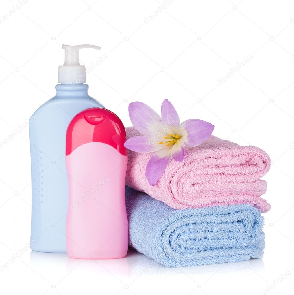 Shampoo and gel bottles with towels and flower