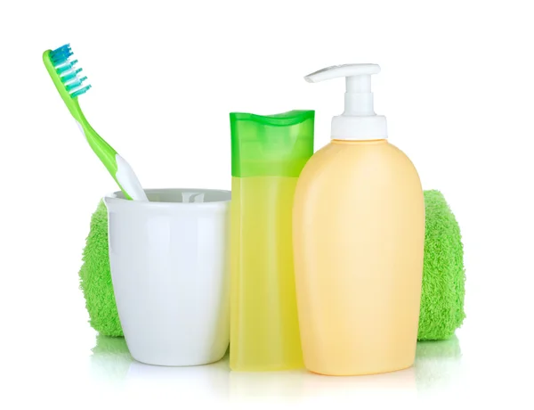 Toothbrush, cosmetics bottles and towel — Stock Photo, Image