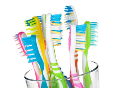 Colorful toothbrushes in glass clipart