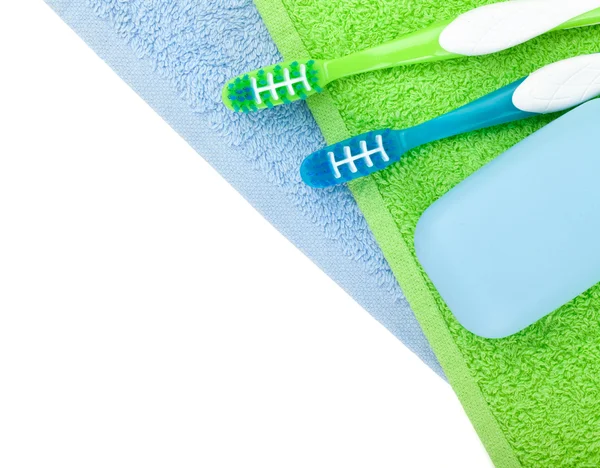 Toothbrushes and soap over towels — Stock Photo, Image