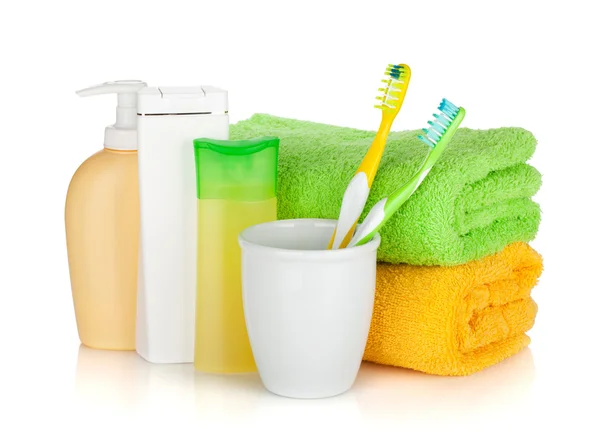 Two colorful toothbrushes, cosmetics bottles and towels — Stock Photo, Image