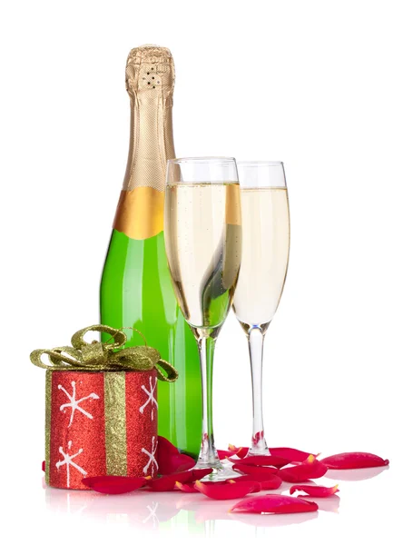 Dos copas de champán, decoración navideña y pétalos de rosa —  Fotos de Stock