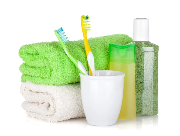 Two colorful toothbrushes, cosmetics bottles and towels — Stock Photo, Image