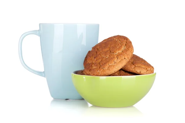 Cup of milk and bowl with cookies — Stock Photo, Image