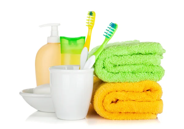 Two colorful toothbrushes, cosmetics bottles and towels — Stock Photo, Image