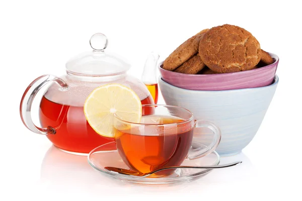 Glass cup and teapot of black tea with lemon and cookies — Stock Photo, Image