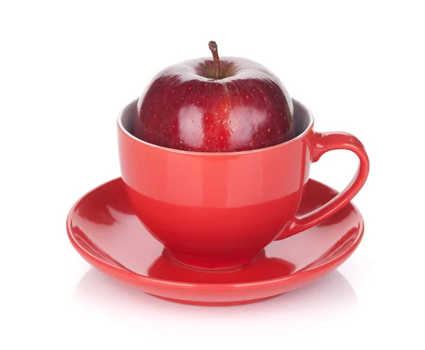Dojrzałe czerwone jabłko w filiżanki herbaty — Zdjęcie stockowe