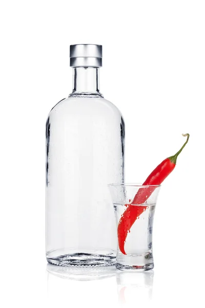 Flaska vodka och shot glas med röd chilipeppar — Stockfoto