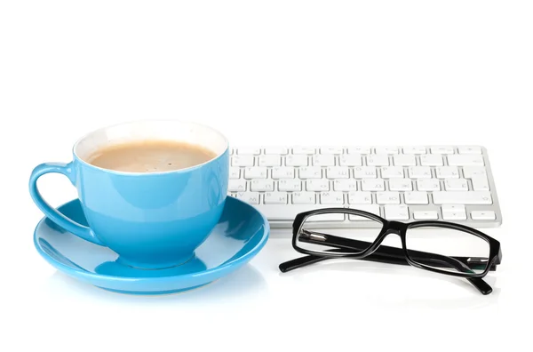 Blå kaffe cup, glasögon och dator tangentbord — Stockfoto