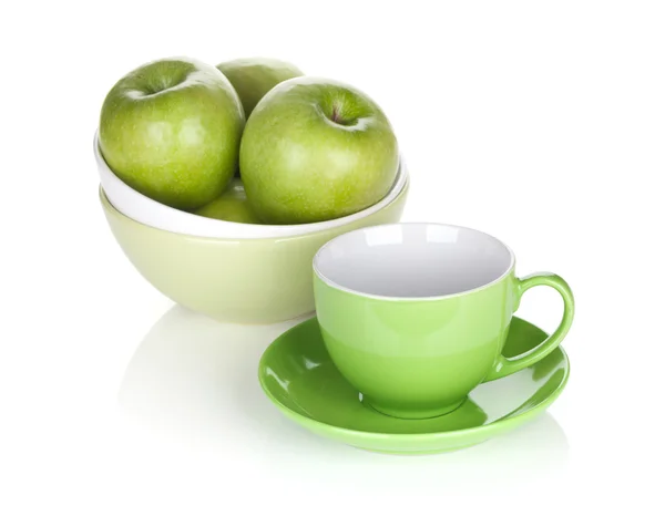 Green apples in fruit bowl and tea cup — Stock Photo, Image