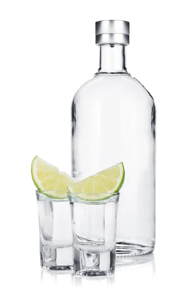 Flaska vodka och shot glas med lime skiva — Stockfoto