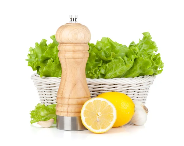 Lettuce in basket with lemons and pepper shaker — Stock Photo, Image