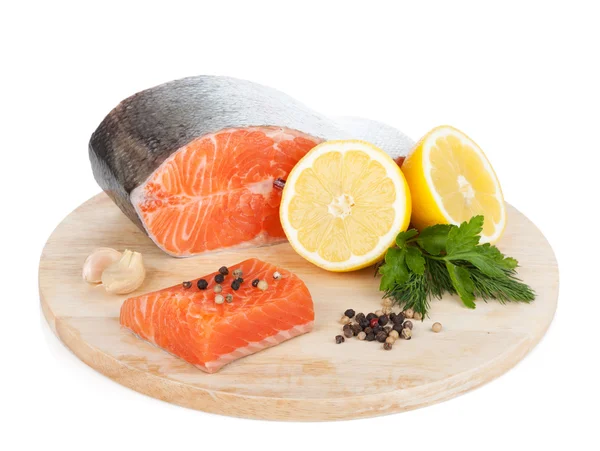 Salmon with herbs and lemon slices on cutting board — Stock Photo, Image