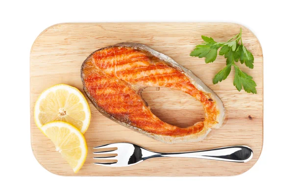 Grilled salmon with lemon slices and parsley on cutting board — Stock Photo, Image