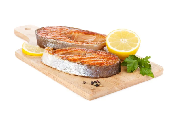 Grilled salmon with lemon and herbs on cutting board — Stock Photo, Image