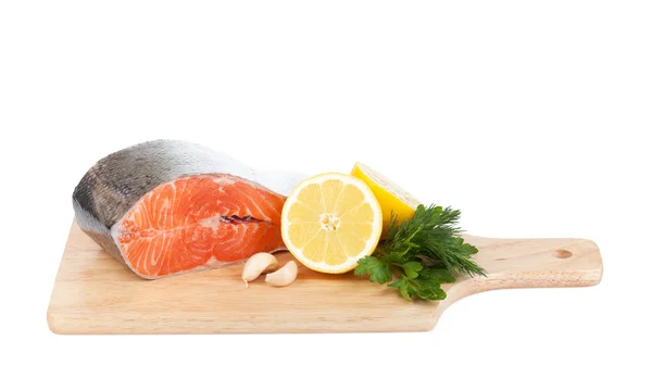 Salmon on cutting board with lemons and herbs — Stock Photo, Image