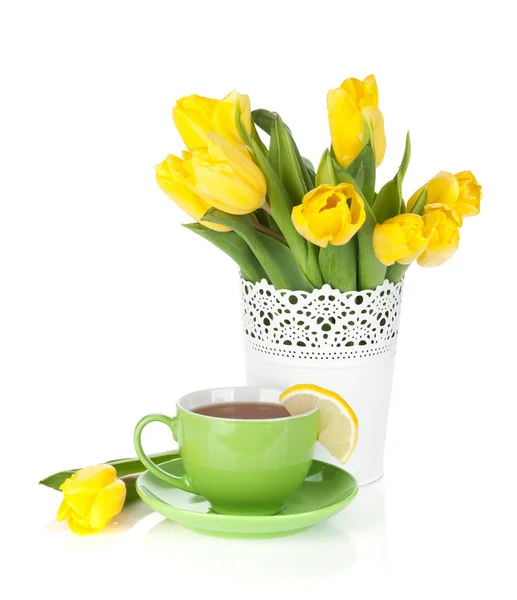 Żółte tulipany i filiżanki herbaty z plasterkiem cytryny — Zdjęcie stockowe
