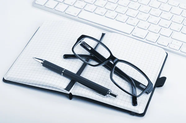 Office supplies, glasses and computed keyboard — Stock Photo, Image