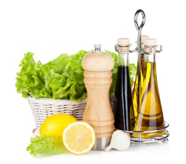 Lettuce in basket with lemon fruits, pepper shaker, olive oil an clipart