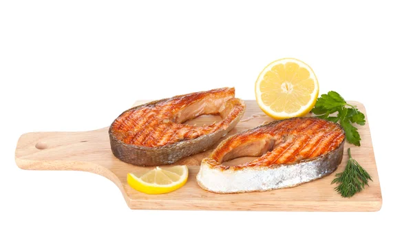 Grilled salmon with lemon and herbs on cutting board — Stock Photo, Image