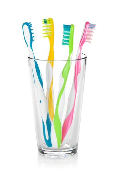 Cepillos de dientes coloridos en vidrio —  Fotos de Stock