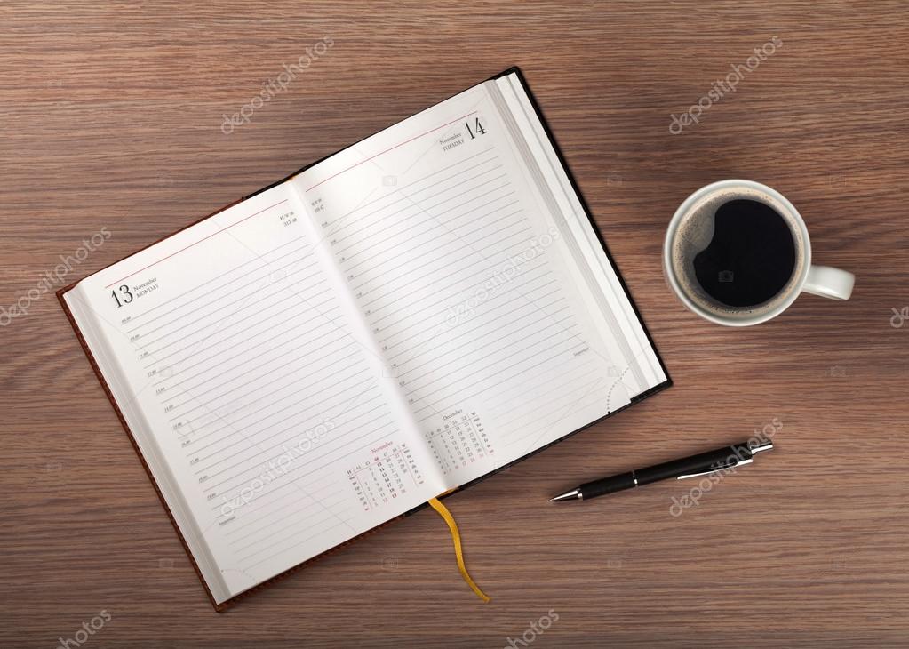 Notepad and coffee cup on wood table