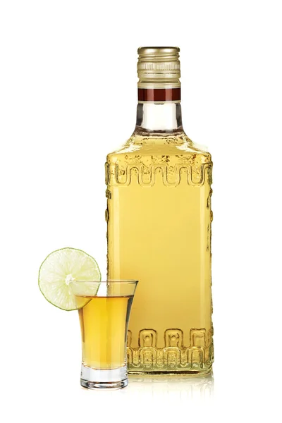 Botella de tequila de oro y chupito con rodaja de lima — Foto de Stock