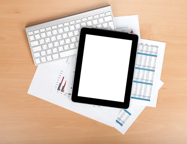 Tablet mit leerem Bildschirm über Papier mit Zahlen und Diagrammen — Stockfoto