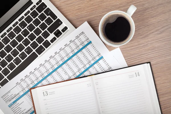 Kladblok, laptop en koffie cup op houten tafel — Stockfoto