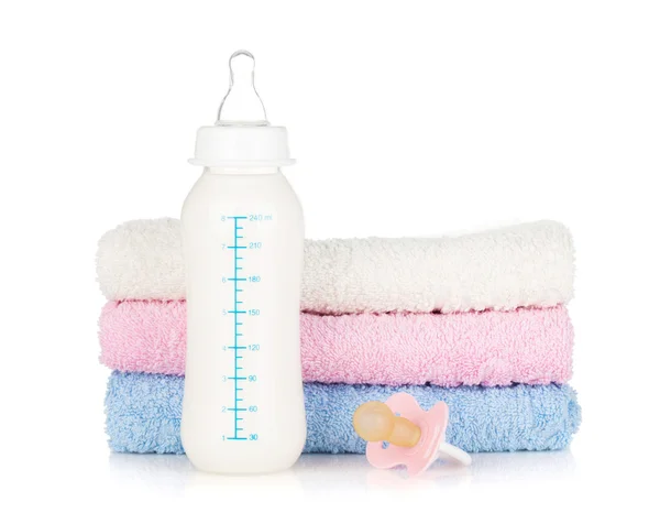 Baby bottle, pacifier and towels — Stock Photo, Image