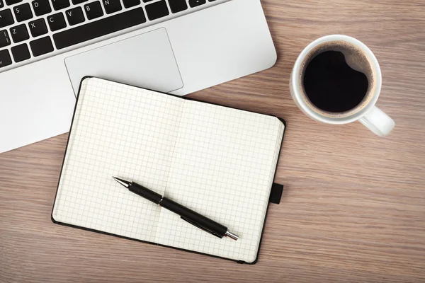 Kladblok, laptop en koffie cup op houten tafel — Stockfoto