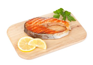 limon ve otlar kesme tahtası üzerinde ızgara somon