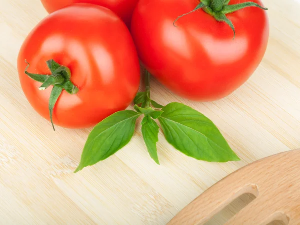 Tres tomates maduros y albahaca —  Fotos de Stock