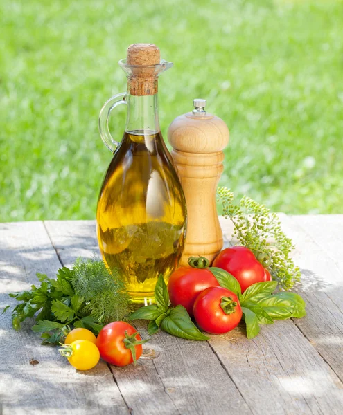 Tomates frescos maduros, botella de aceite de oliva, pimentero y hierbas —  Fotos de Stock