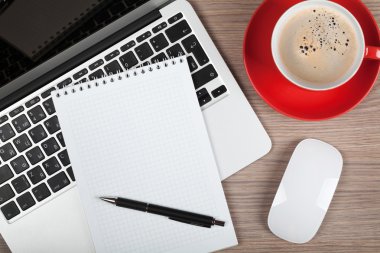 laptop ve kahve fincan üzerinde boş bir not defteri