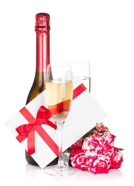 Пляшка шампанського та квіти червоної троянди — стокове фото